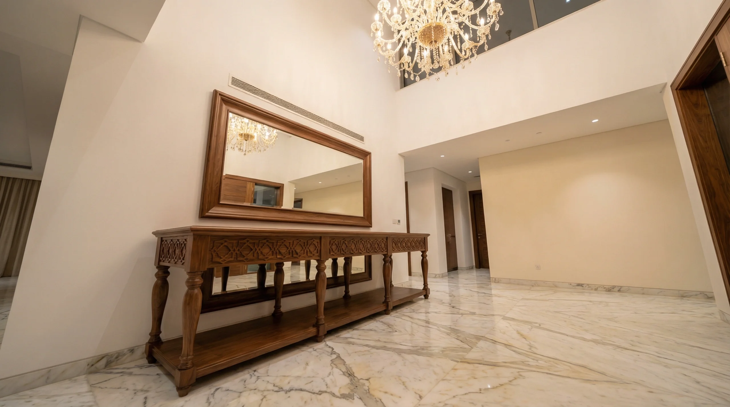 2.8-metre custom walnut console table in Emirates Hills villa entryway, designed and crafted by Karnak Carpentry