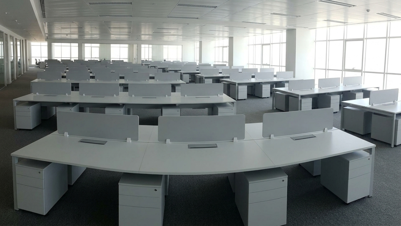 Massive government office fit-out with rows of custom light gray MFC workstations in Fujairah