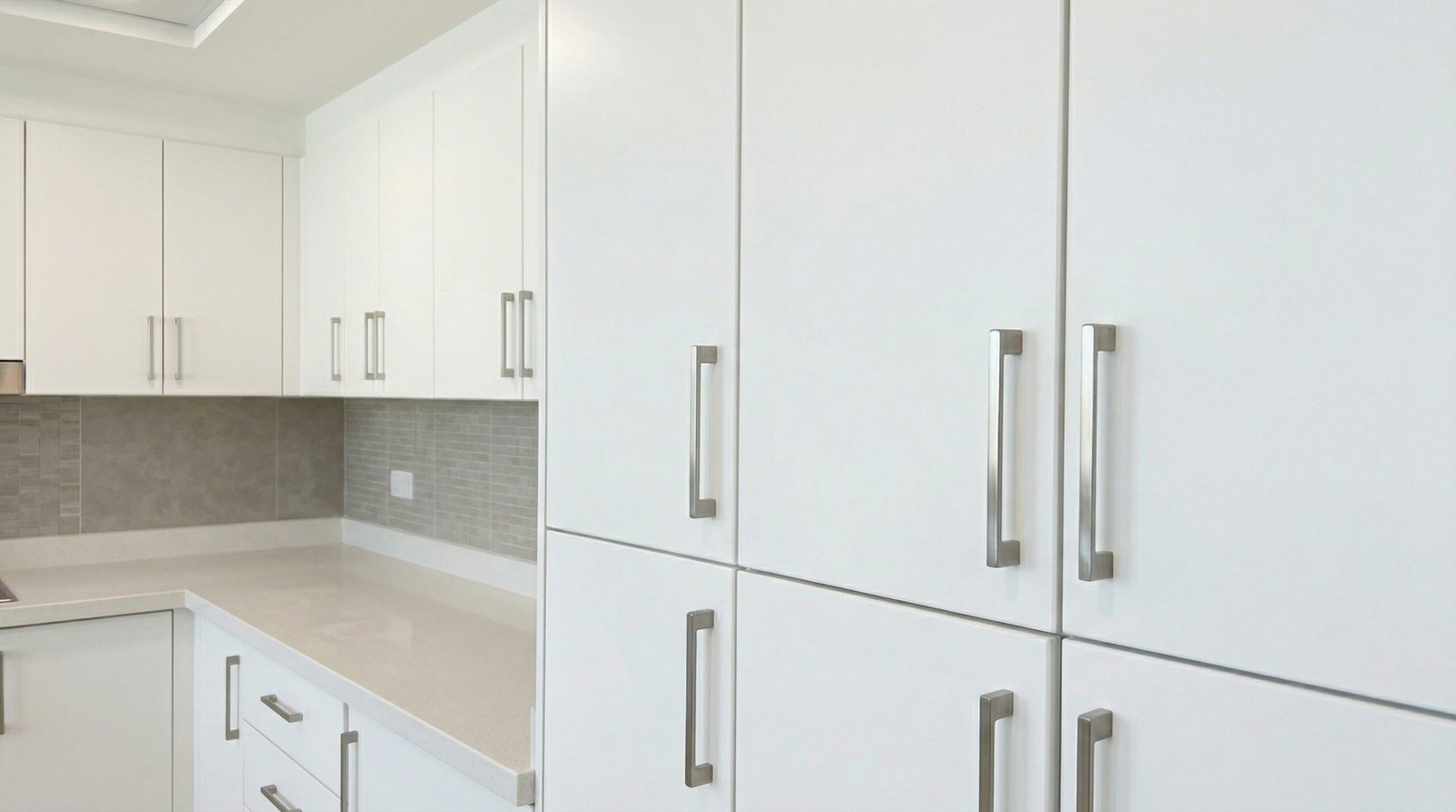 Professionally maintained kitchen cabinets with realigned soft-close hinges and new handles in UAE apartment