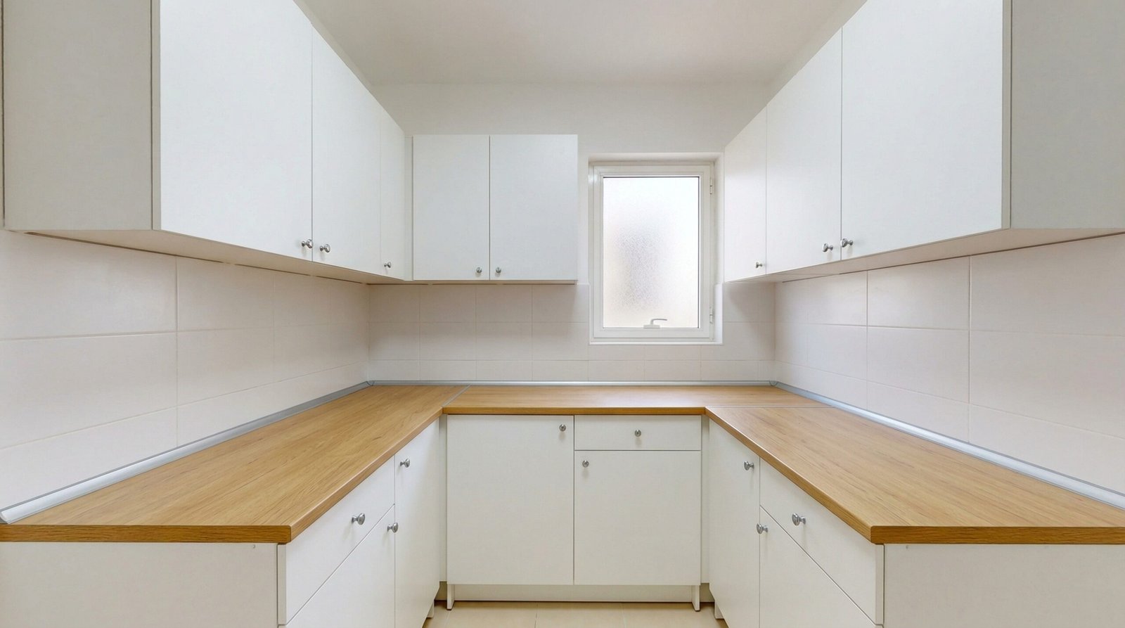 Budget-friendly white laminate kitchen cabinet installation in compact UAE apartment at International City