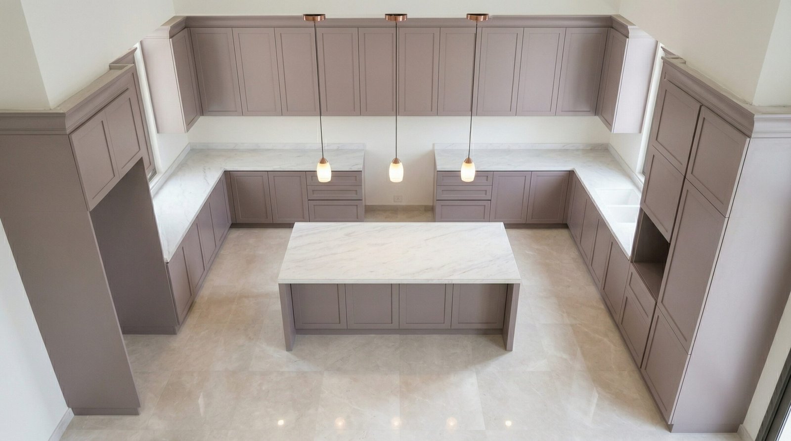 Aerial view of completed U-shaped kitchen cabinet installation in dusty rose-grey with marble island in UAE home