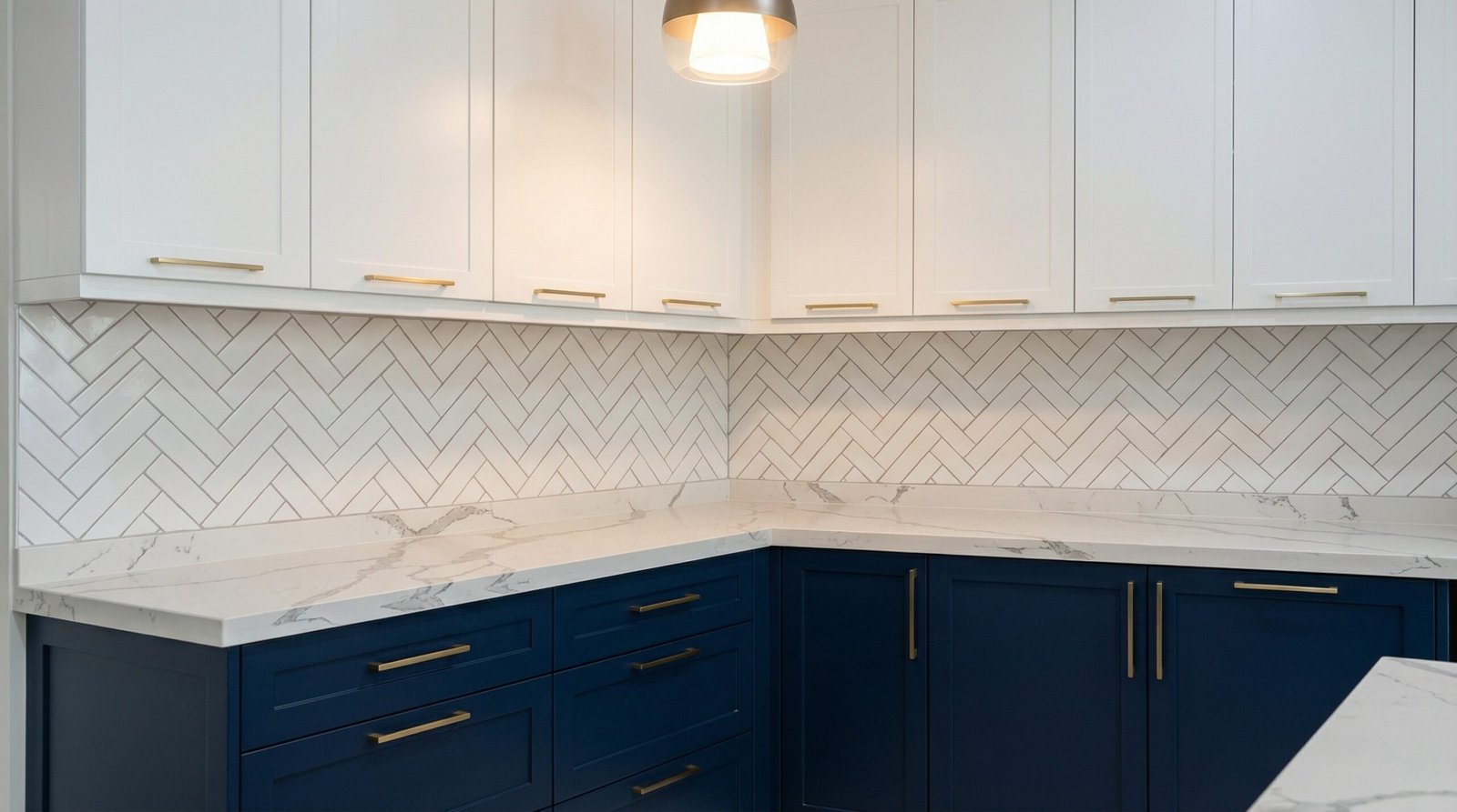 Two-tone navy and white kitchen cabinets with brushed gold handles and Calacatta quartz countertop in UAE villa