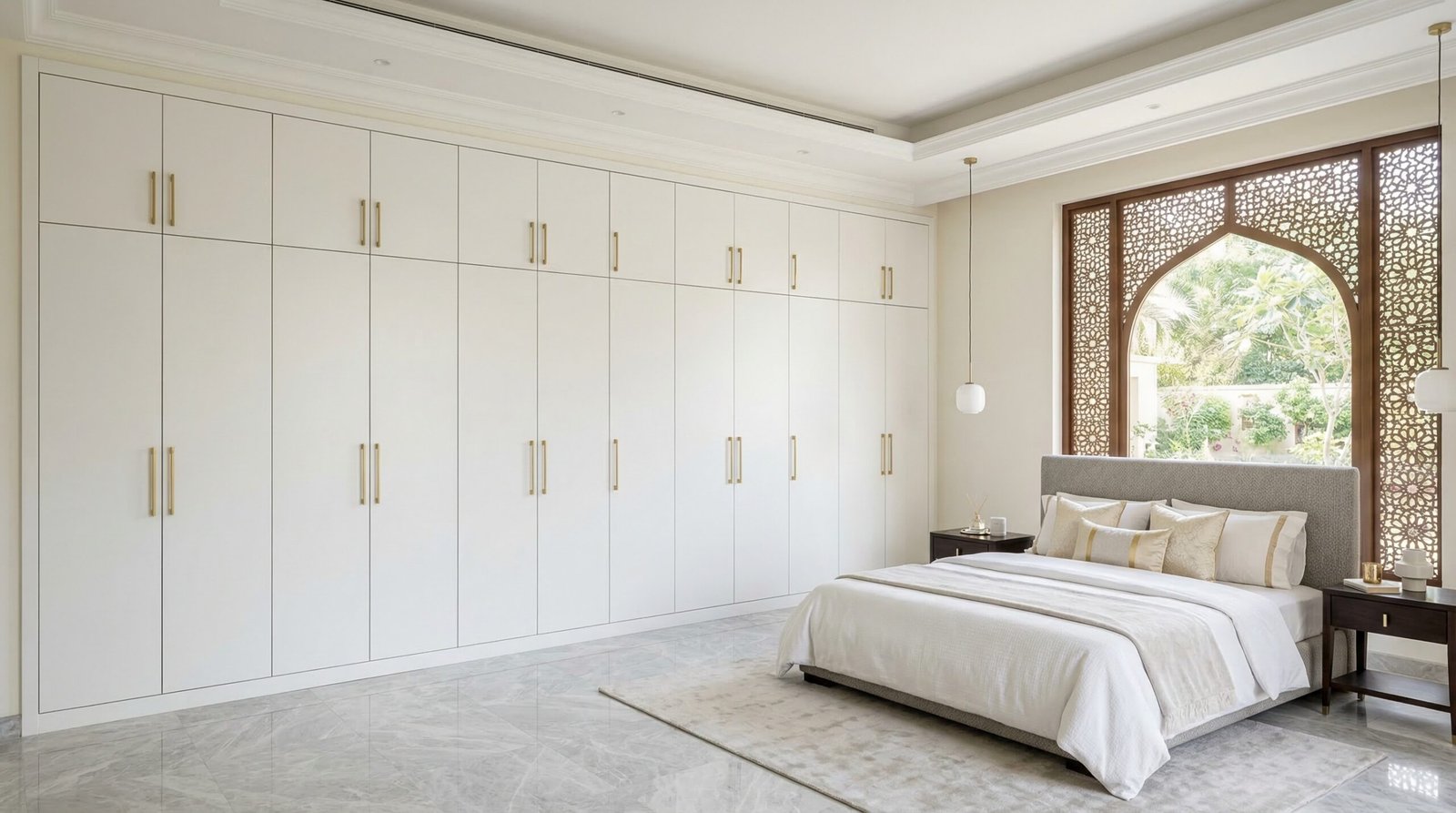 Custom built-in floor-to-ceiling wardrobe in matte white lacquer with brushed gold handles installed in Dubai villa master bedroom by Karnak Carpentry UAE