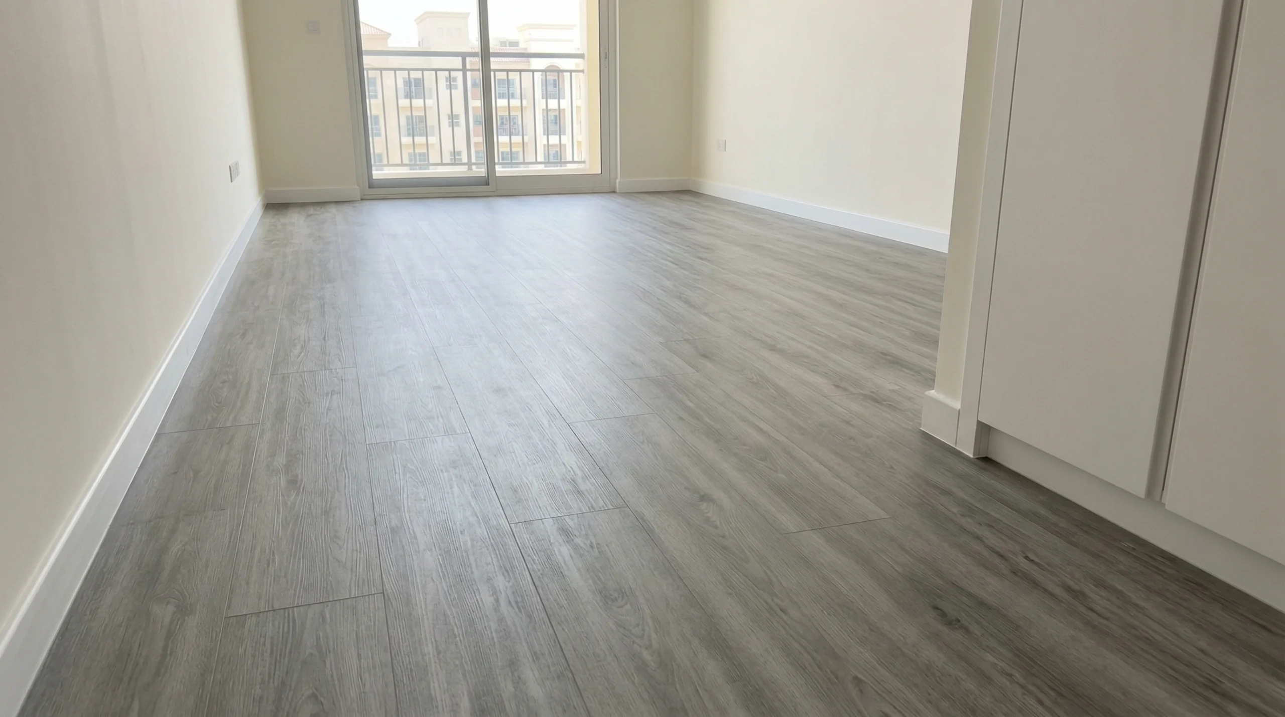 High-quality grey wood-grain SPC flooring flawlessly installed in a JVC apartment by Karnak Carpentry.