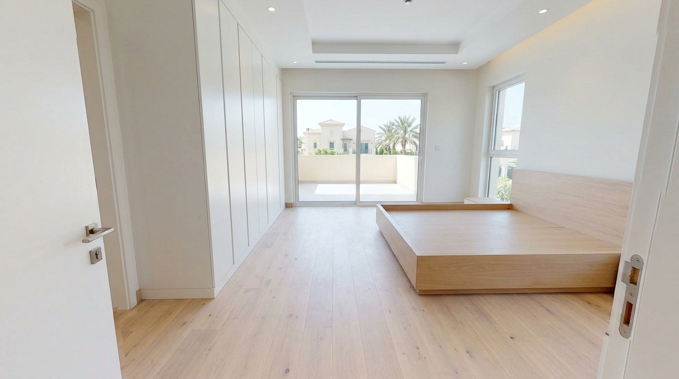 Wide-plank whitewashed oak flooring installed in an Arabian Ranches bedroom with fitted joinery by Karnak.