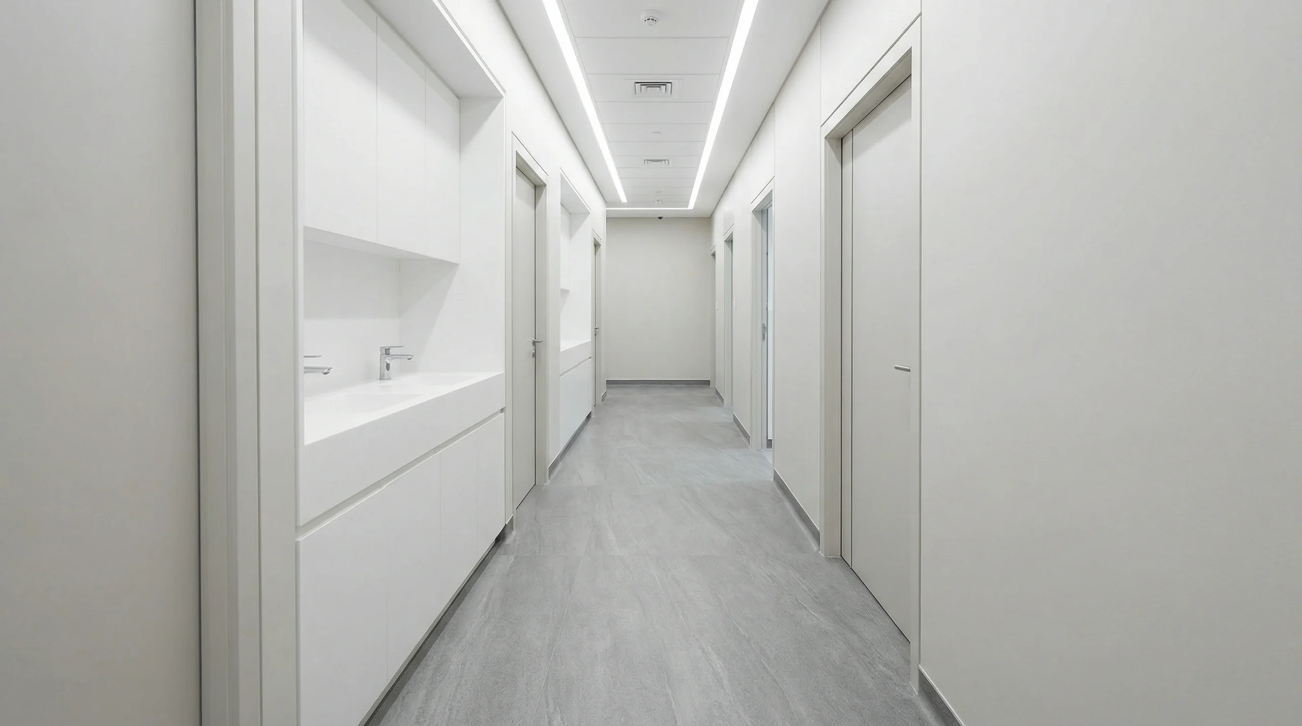 Hygienic grey stone-effect SPC flooring in an Abu Dhabi healthcare clinic corridor by Karnak Carpentry.