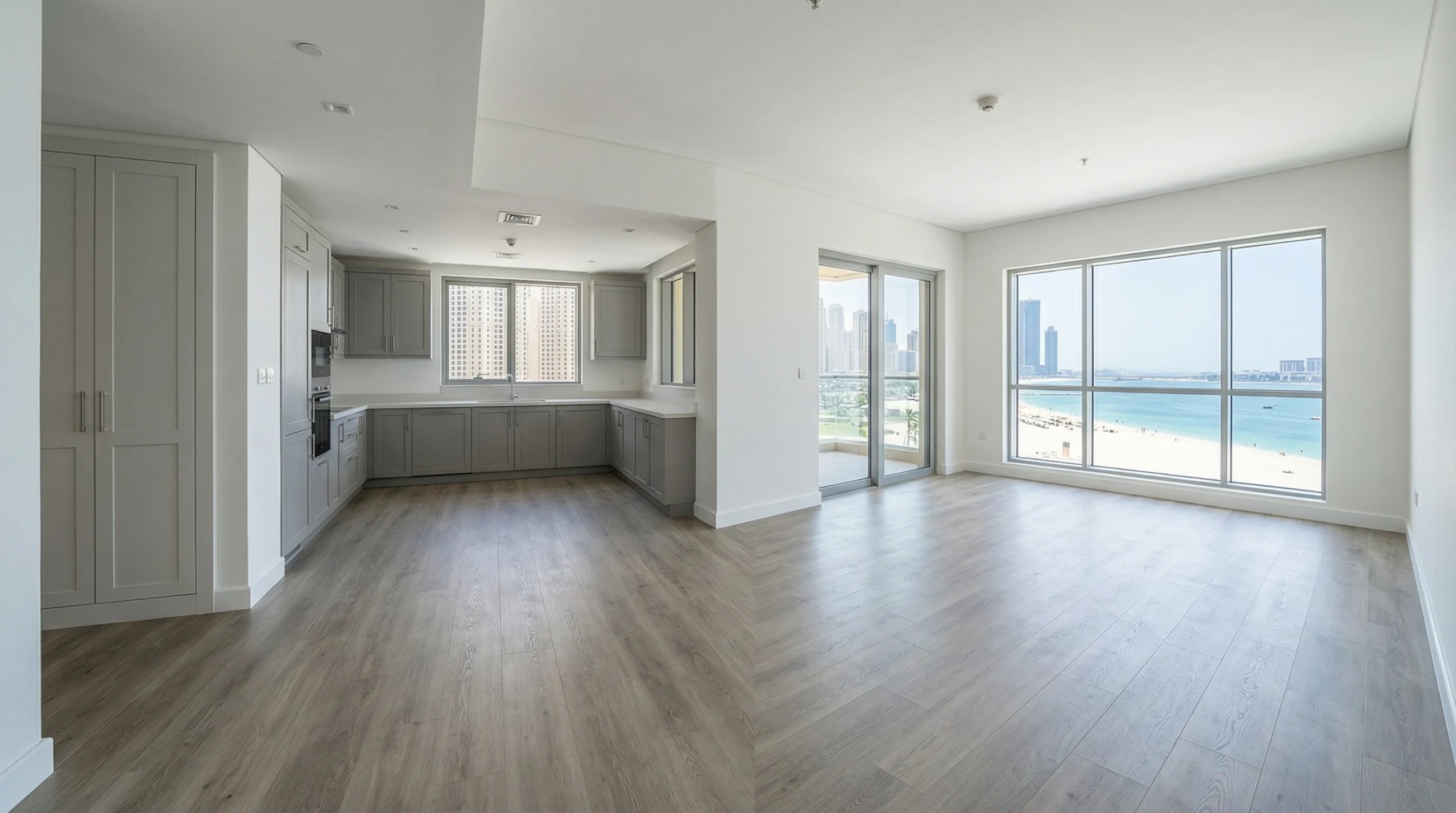 Wide-plank greige oak SPC flooring in a modern JBR apartment living area by Karnak Carpentry.