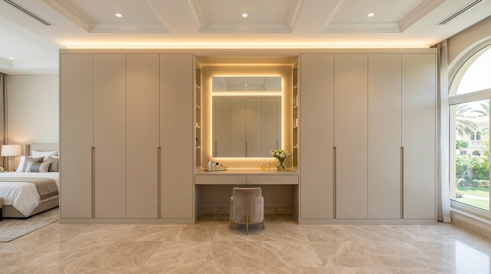 Built-in wardrobe wall with integrated central dressing table section in matte sand lacquer installed in Emirates Hills villa by Karnak Carpentry Dubai UAE