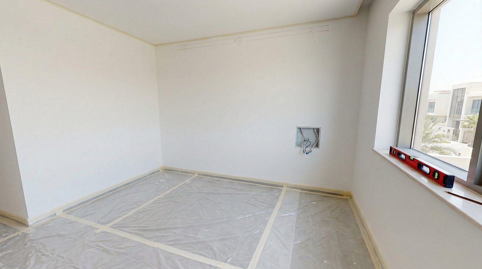 Sliding wardrobe installation in progress with top track fixed and first door panel being hung in Dubai Marina apartment by Karnak Carpentry UAE
