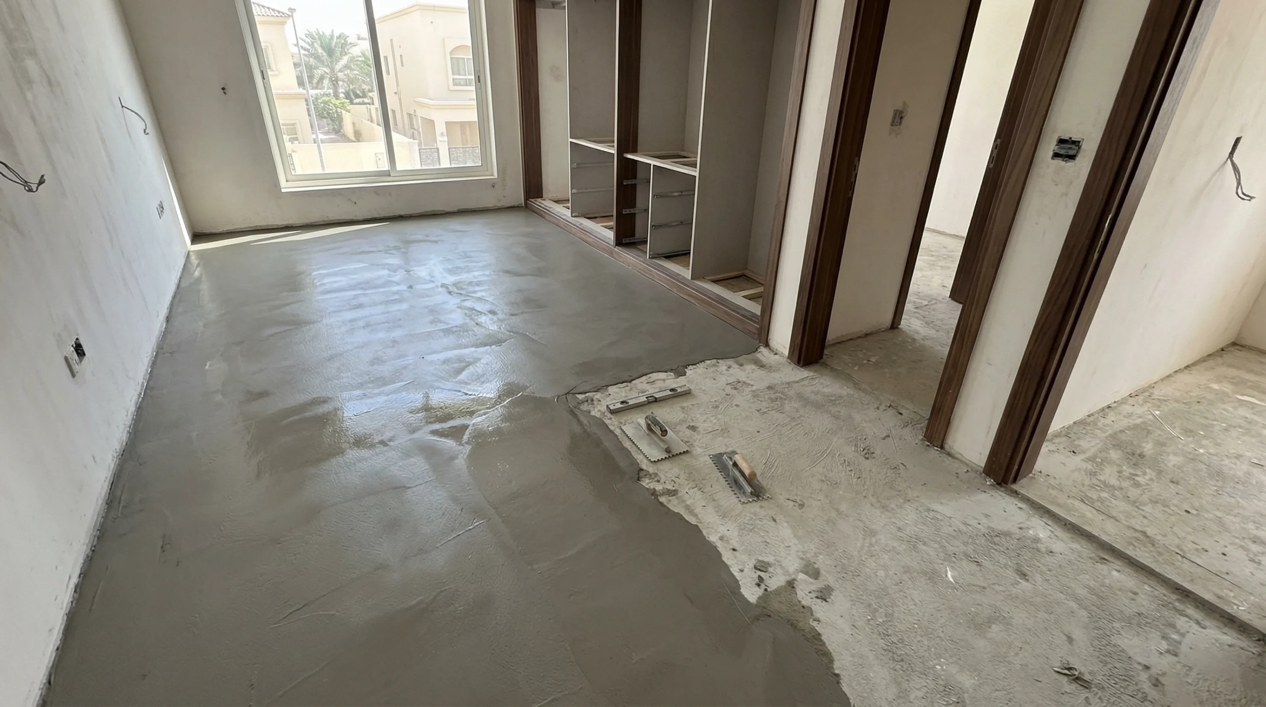 smooth self-leveling compound applied to raw concrete subfloor ready for laminate installation in a Sharjah villa.