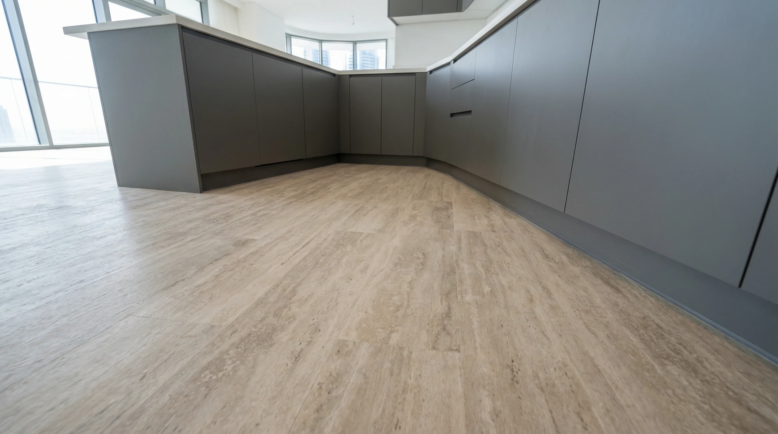 Travertine stone effect SPC flooring in a modern grey kitchen.