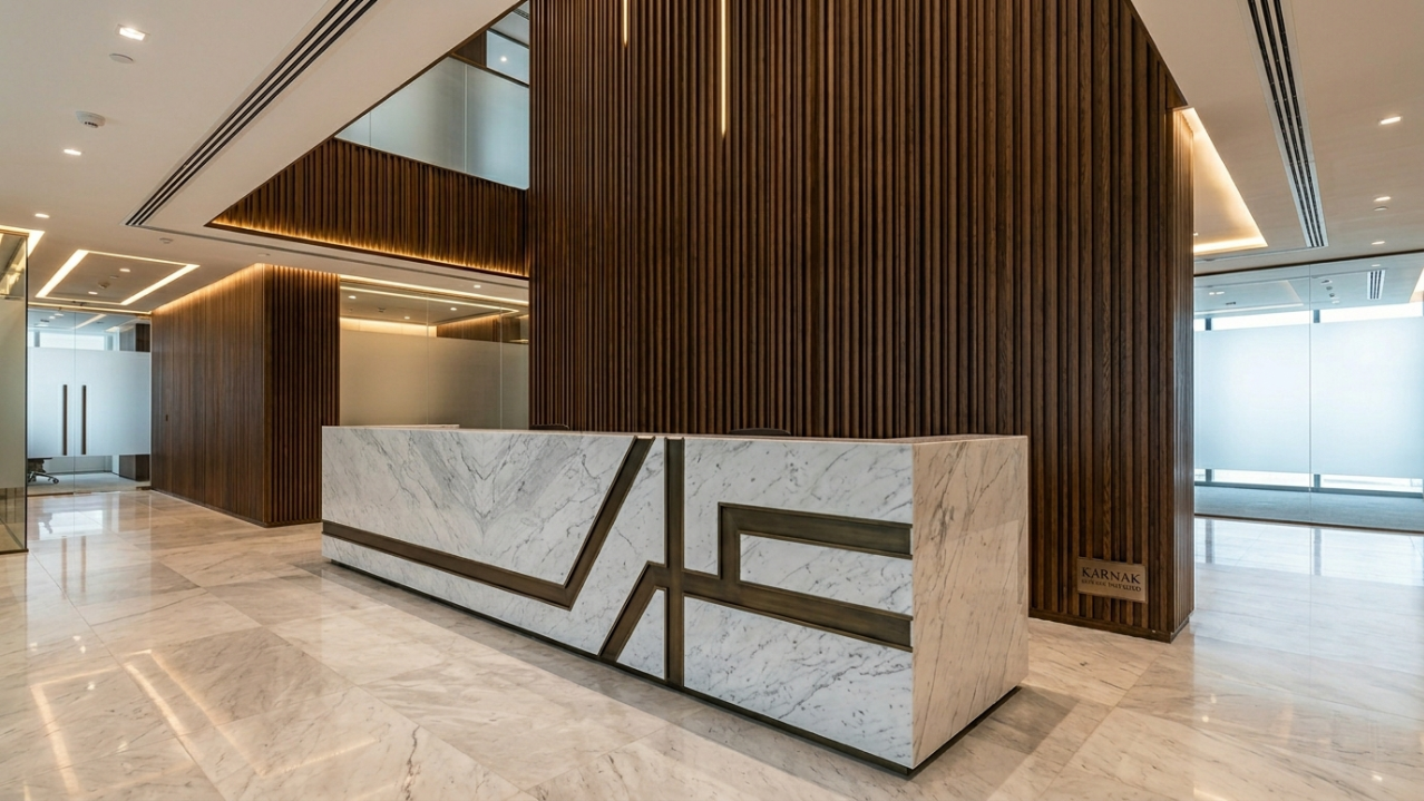 Massive Carrara marble reception desk and textured dark oak slatted feature wall in a Dubai law firm.