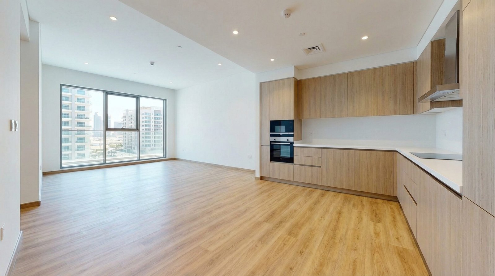 Stylish oak-effect LVT flooring installed throughout a Dubai Sports City apartment.