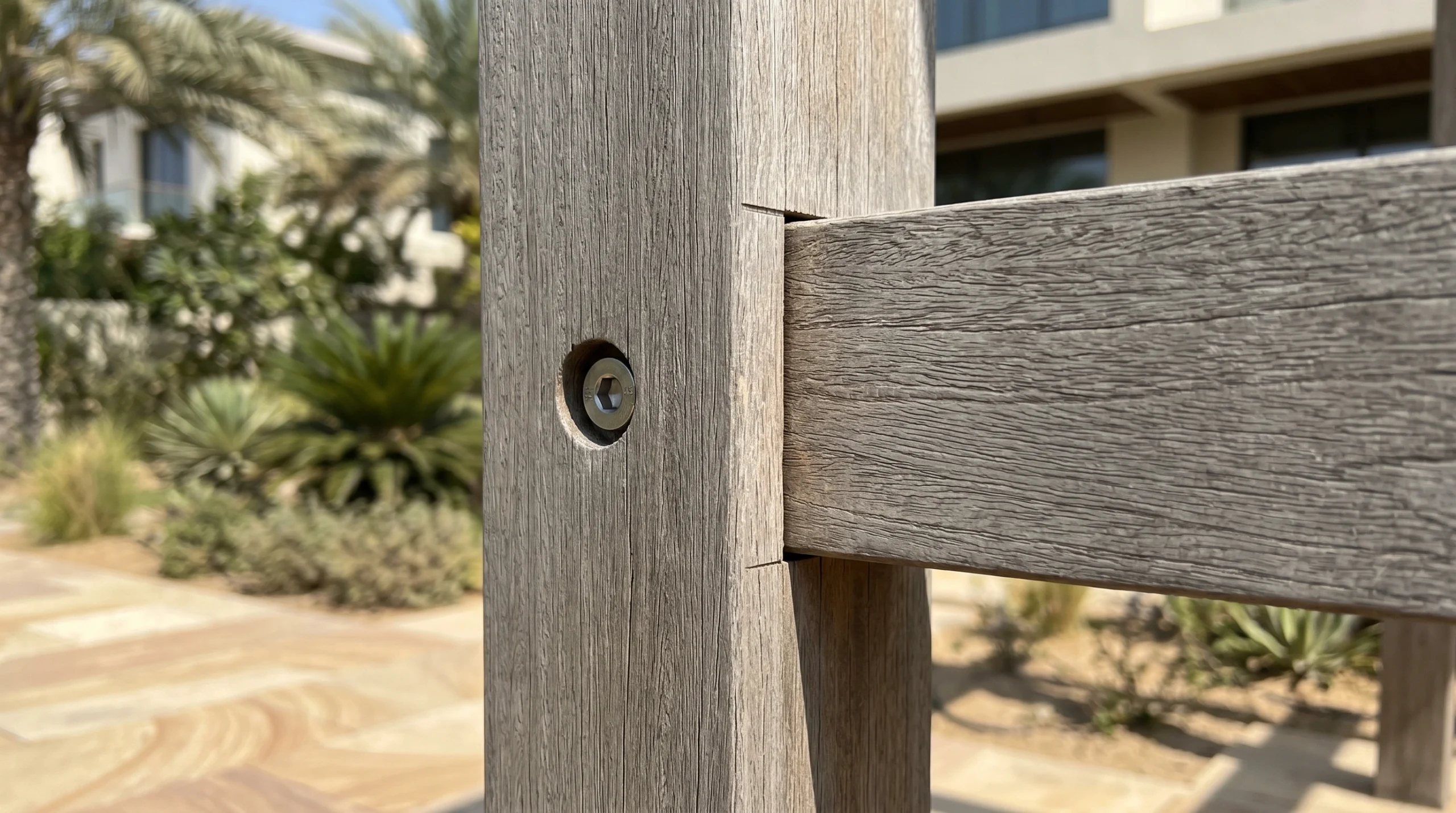 Engineered Ipe hardwood mortise-and-tenon pergola beam joint with thermal expansion gap and stainless bolt in UAE garden by Karnak Carpentry