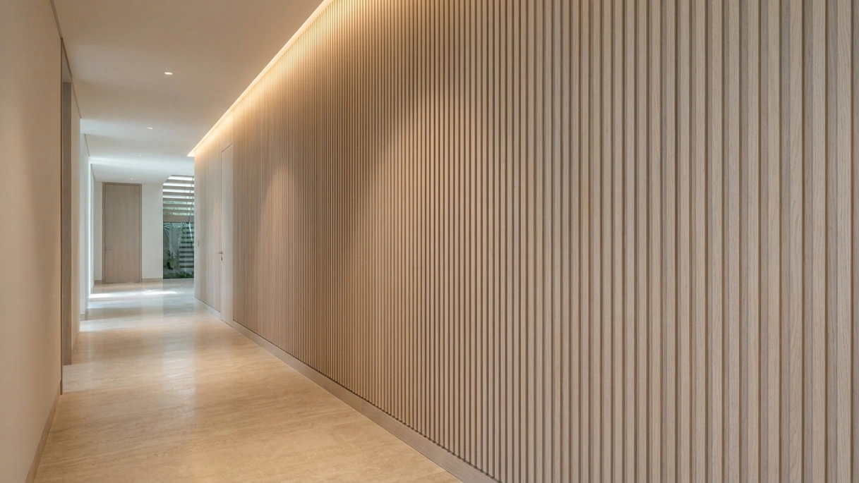 Custom built-in full-height fluted limed oak panel feature wall with LED ceiling wash in Al Barari Dubai villa corridor